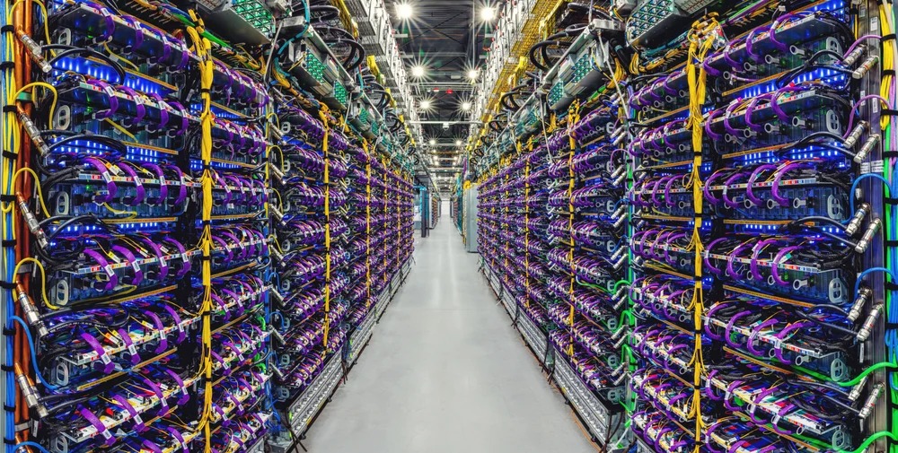 Une rangée de supercalculateurs accélérateurs d'IA Cloud TPU v5p dans un centre de données Google.